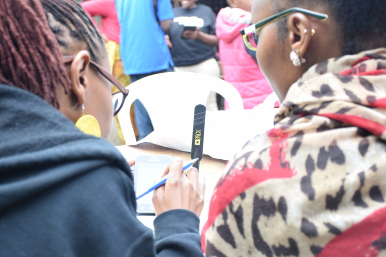 Juliana Rotich taking one of the volunteers through the connection process